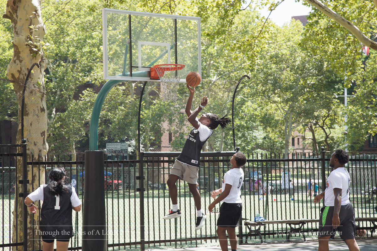 A player in the air going up for a layup at the Cops vs. Kids Basketball game in Parkchester, Bronx